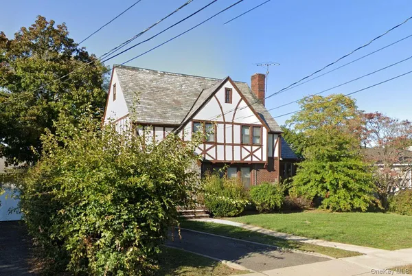 a view of a house with a tree and wooden fence