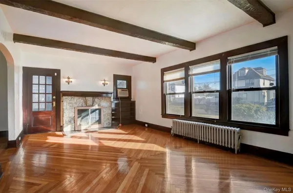 a view of an empty room with a fireplace and a window