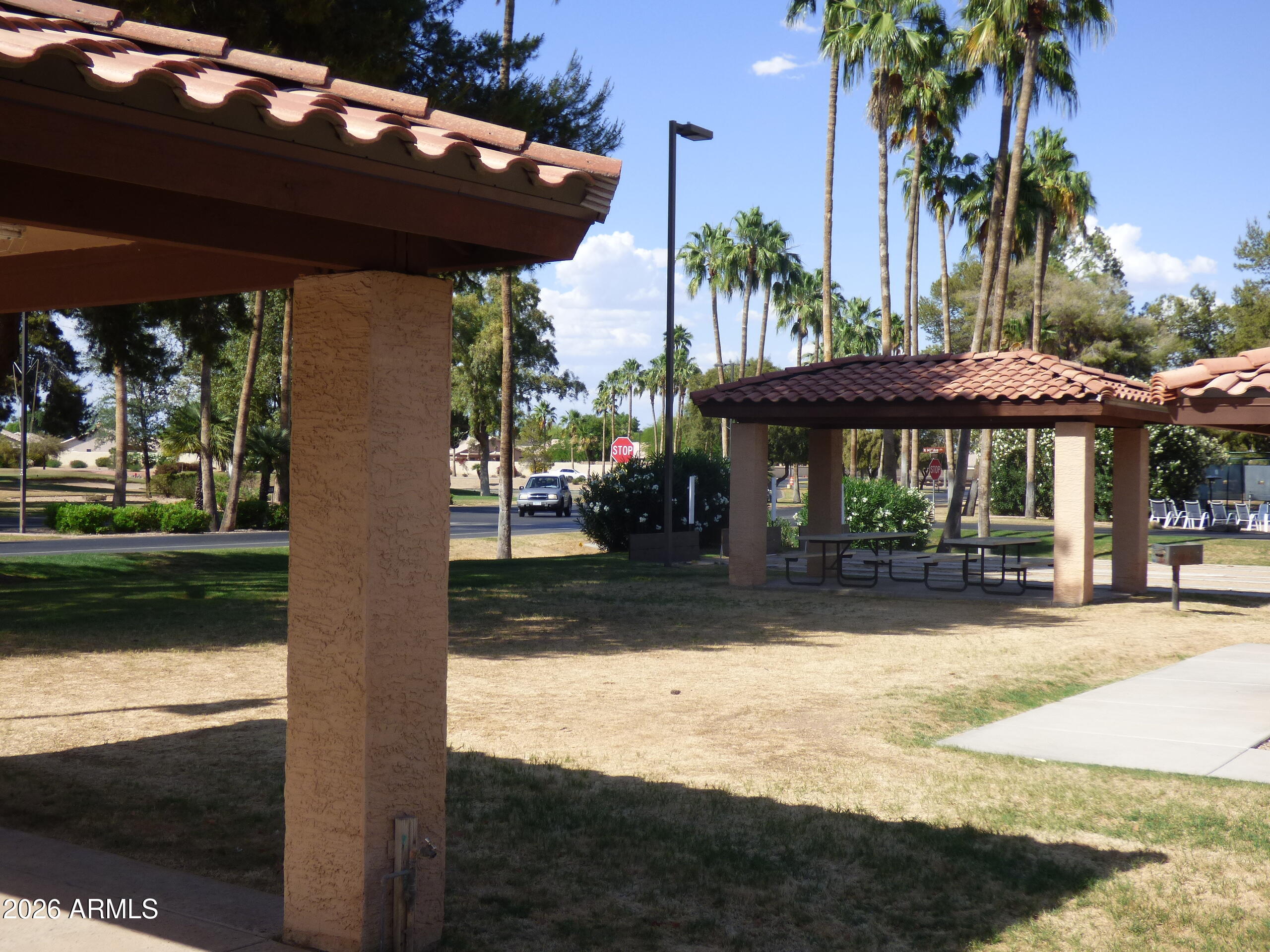 14300 West Bell Road, Unit 349 Surprise, AZ 85374 - Photo 26 of 32 a view of a patio with a table chairs under an umbrella