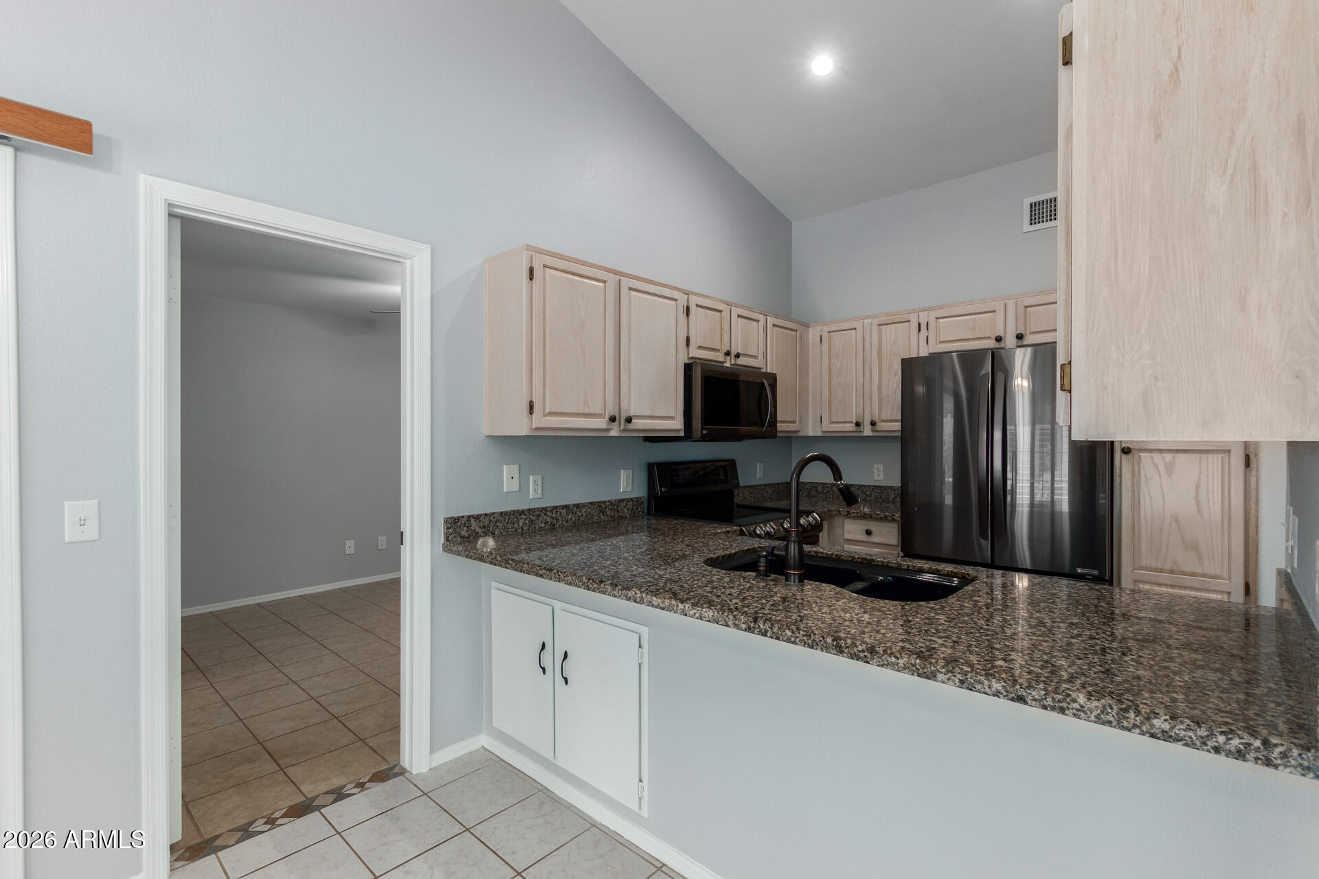 14300 West Bell Road, Unit 349 Surprise, AZ 85374 - Photo 6 of 32 a kitchen with granite countertop a sink a stove a microwave a refrigerator and cabinetry