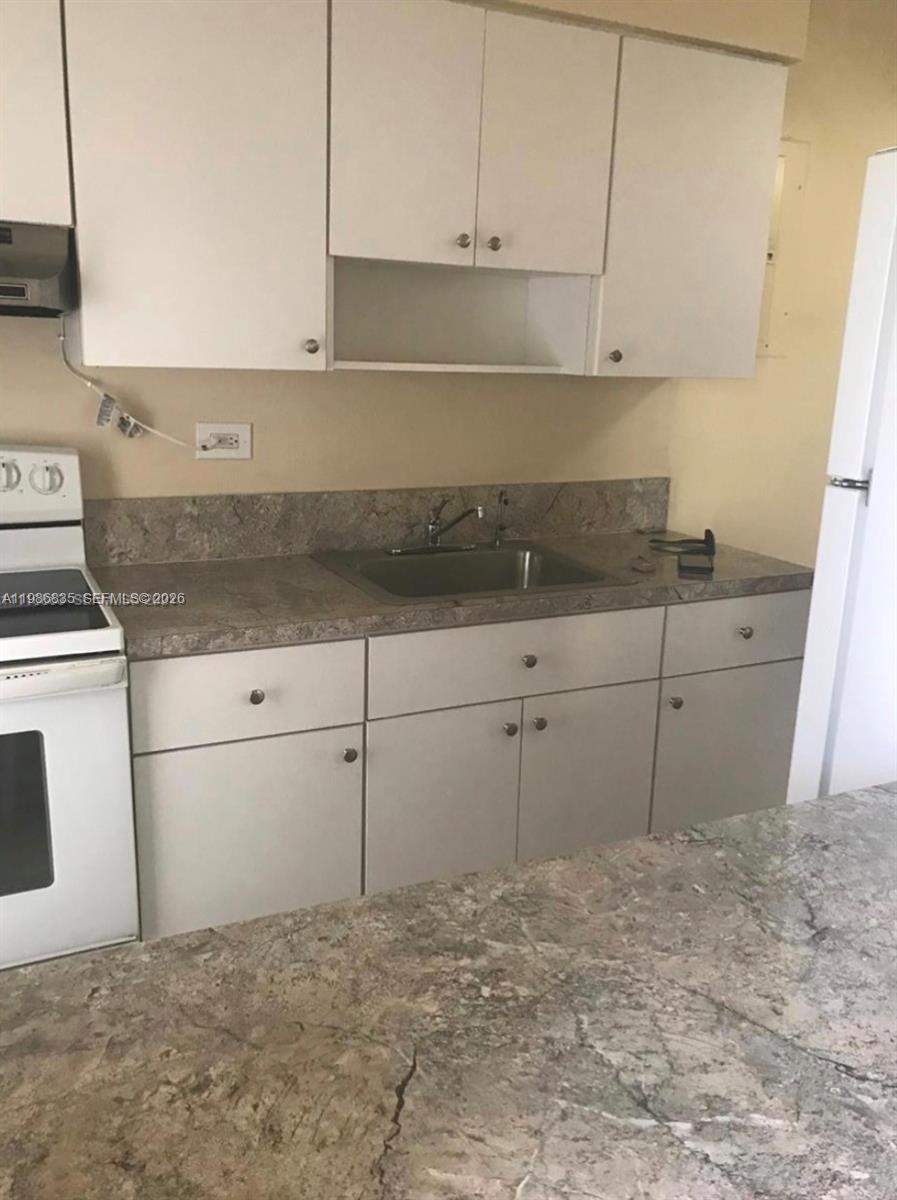 70 Northwest 77th Street, Unit 9 Miami, FL 33150 - Photo 13 of 13 a kitchen with white cabinets and white appliances