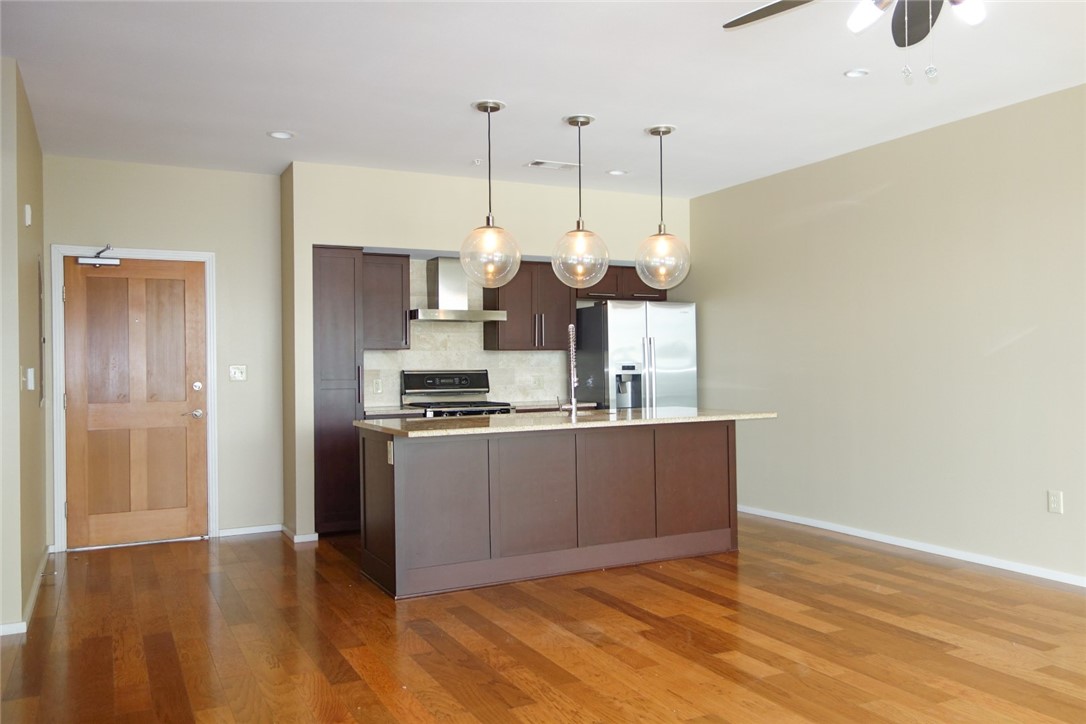 1600 Barton Springs Road, Unit 1407 Austin, TX 78704 - Photo 7 of 38 a kitchen with stainless steel appliances granite countertop a stove a refrigerator and a wooden floor