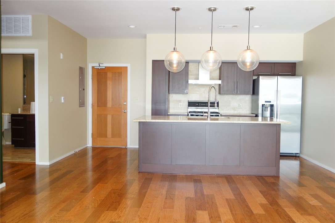 1600 Barton Springs Road, Unit 1407 Austin, TX 78704 - Photo 8 of 38 a view of a kitchen with wooden floor and stainless steel appliances