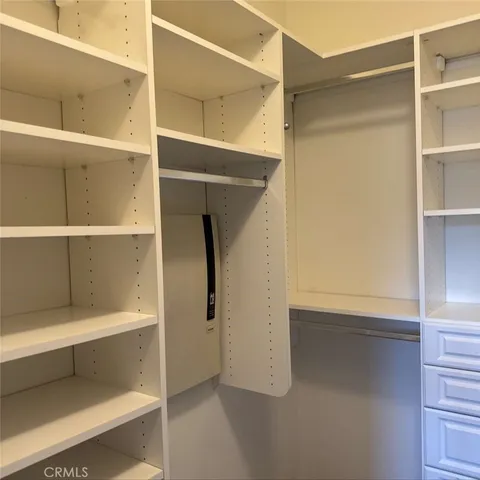 a view of walk in closet with empty racks