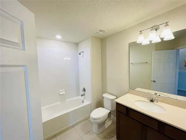 a bathroom with a double vanity sink toilet mirror and bathtub