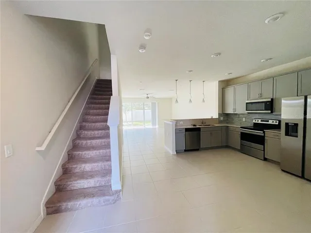 a kitchen with stainless steel appliances a refrigerator and a stove top oven