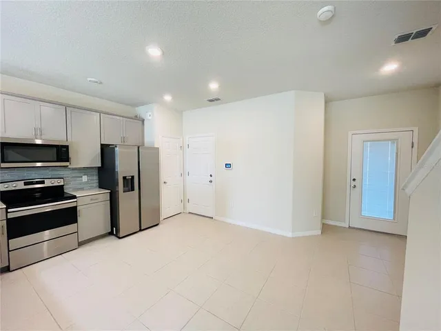 a kitchen with stainless steel appliances a refrigerator and a stove top oven