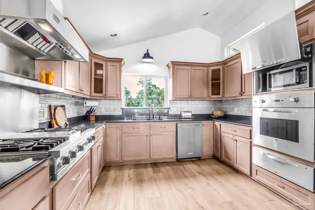 a kitchen with stainless steel appliances granite countertop a stove and cabinets