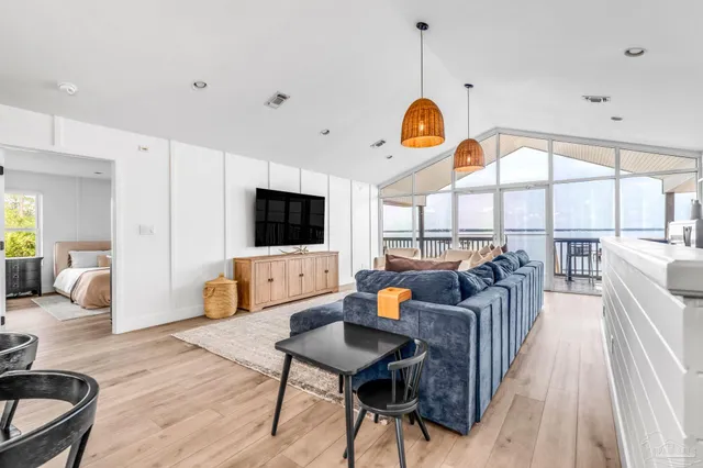 a living room with furniture a flat screen tv and a large window