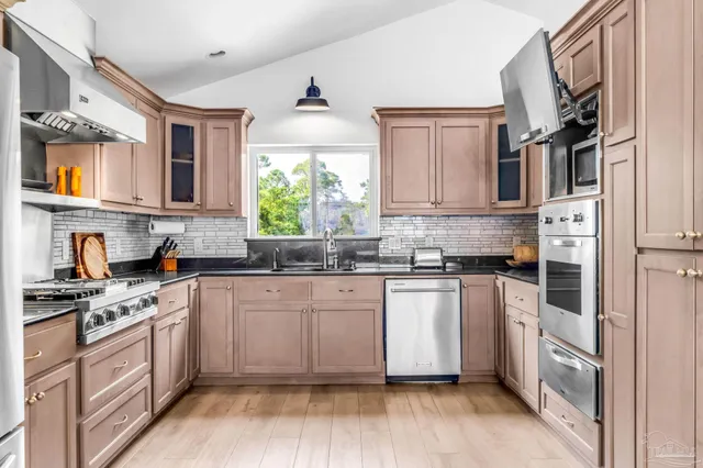 a kitchen with stainless steel appliances granite countertop a stove a sink dishwasher and a refrigerator