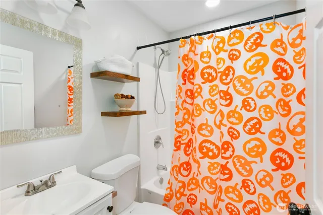 a bathroom with a sink toilet and shower curtain