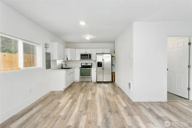 a view of kitchen with refrigerator and window