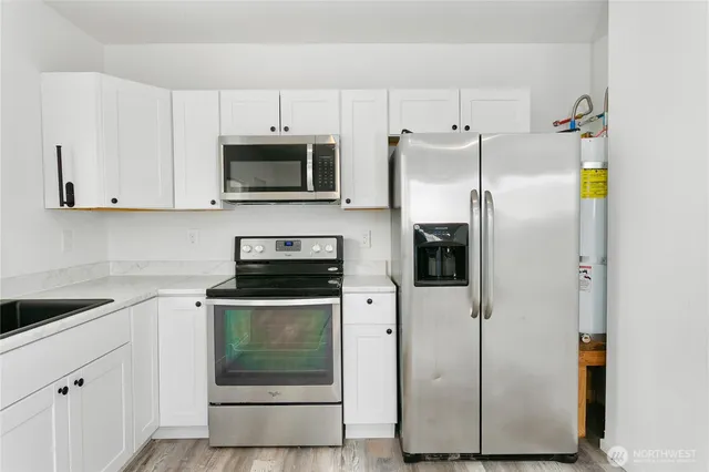 a kitchen with stainless steel appliances white cabinets and a refrigerator