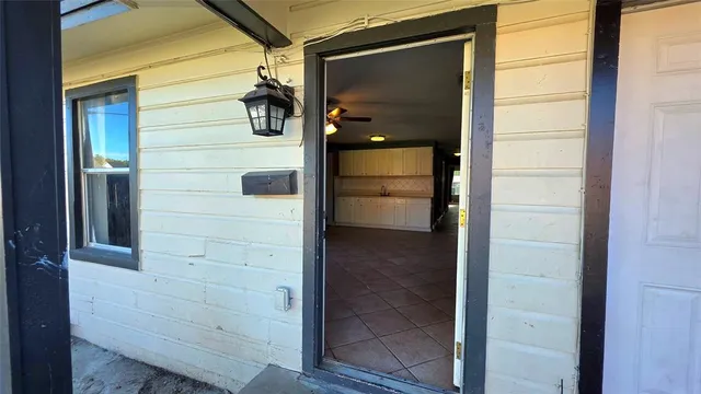 a view of hallway with window and a ceiling fan