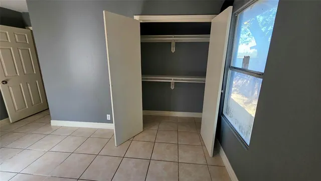 a view of a house with a large tree and wooden fence