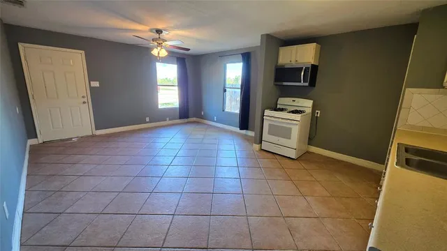 a kitchen with granite countertop white cabinets and stainless steel appliances
