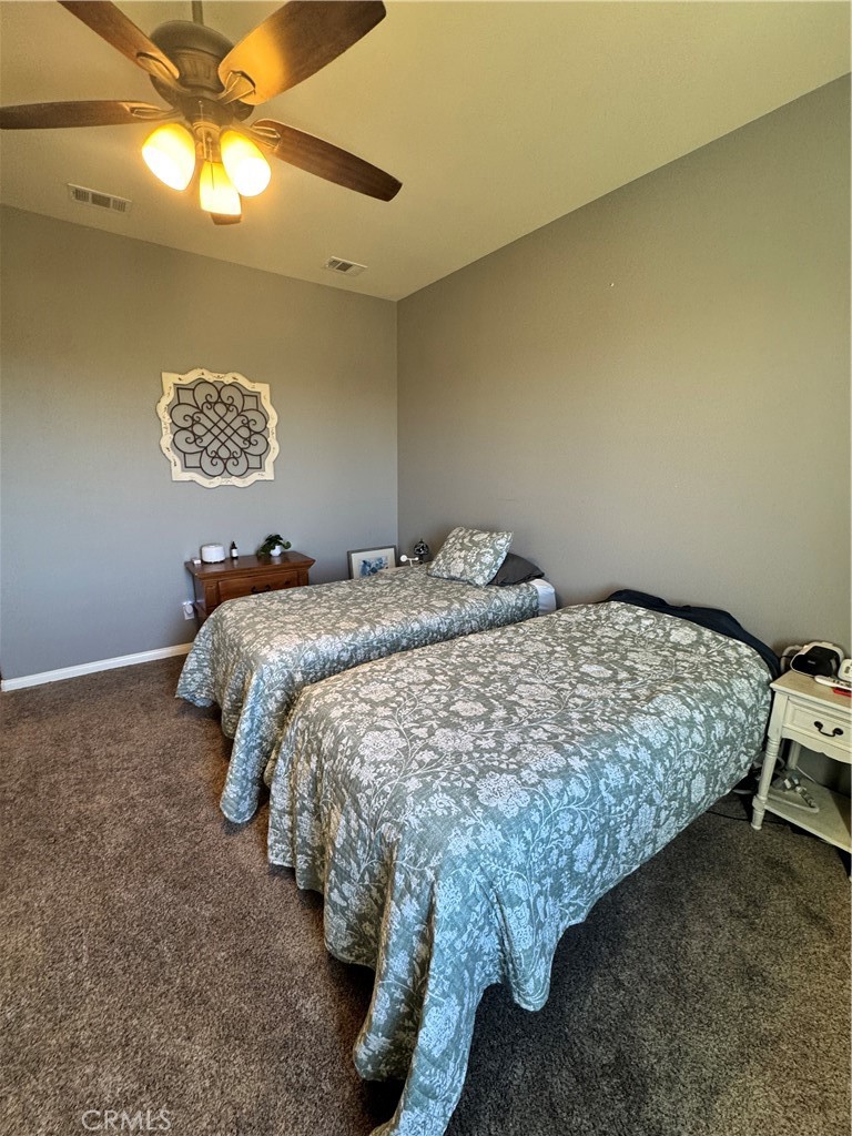11000 Rockaway Glen Road Apple Valley, CA 92308 - Photo 13 of 17 a bed sitting in a bedroom next to a lamp