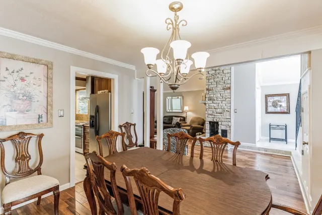a view of a dining room with furniture a chandelier and wooden floor