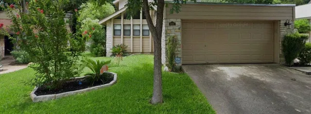 a view of backyard with potted plants and wooden fence