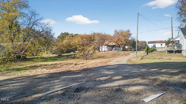 a view of a yard with wooden fence