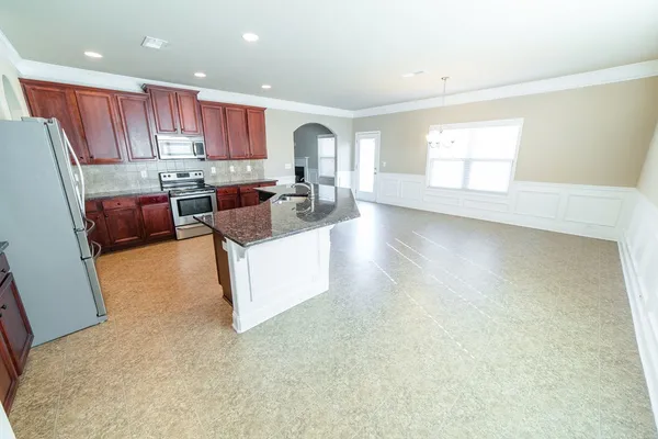 a kitchen with stainless steel appliances granite countertop a sink stove and refrigerator