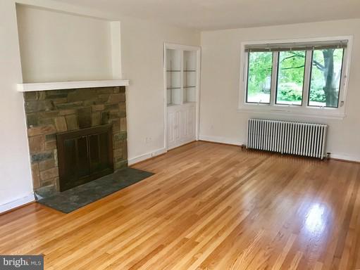 8905 Flower Avenue Silver Spring, MD 20901 - Photo 1 of 17 an empty room with wooden floor fireplace and windows