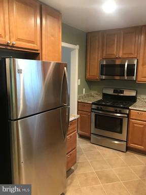 8905 Flower Avenue Silver Spring, MD 20901 - Photo 13 of 17 a kitchen with stainless steel appliances granite countertop a refrigerator stove and microwave