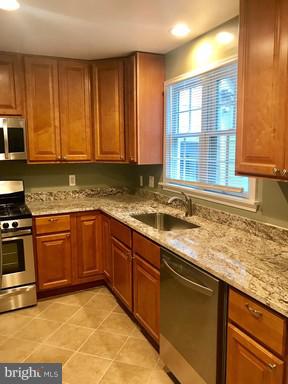 8905 Flower Avenue Silver Spring, MD 20901 - Photo 14 of 17 a kitchen with stainless steel appliances granite countertop a sink stove and cabinets