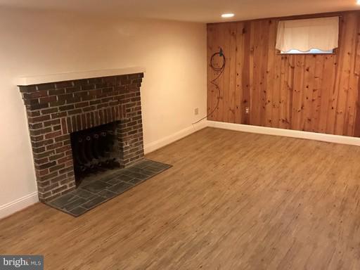 8905 Flower Avenue Silver Spring, MD 20901 - Photo 10 of 17 a living room with wooden floor and a fireplace