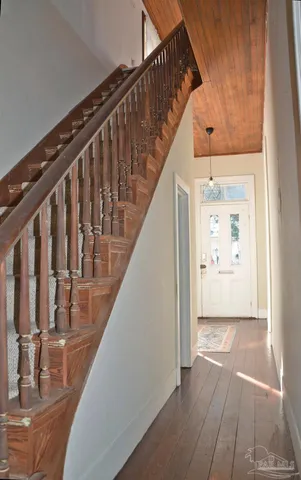 a view of a hallway with wooden floor and staircase