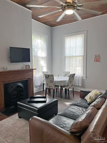 a living room with furniture a flat screen tv and a fireplace
