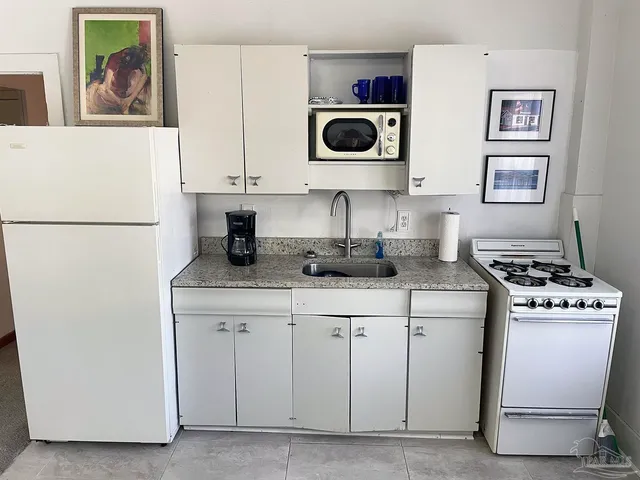 a living room with furniture and a view of kitchen
