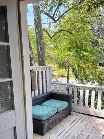 a view of house with wooden deck and furniture