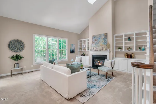 a living room with furniture a large window and a fireplace