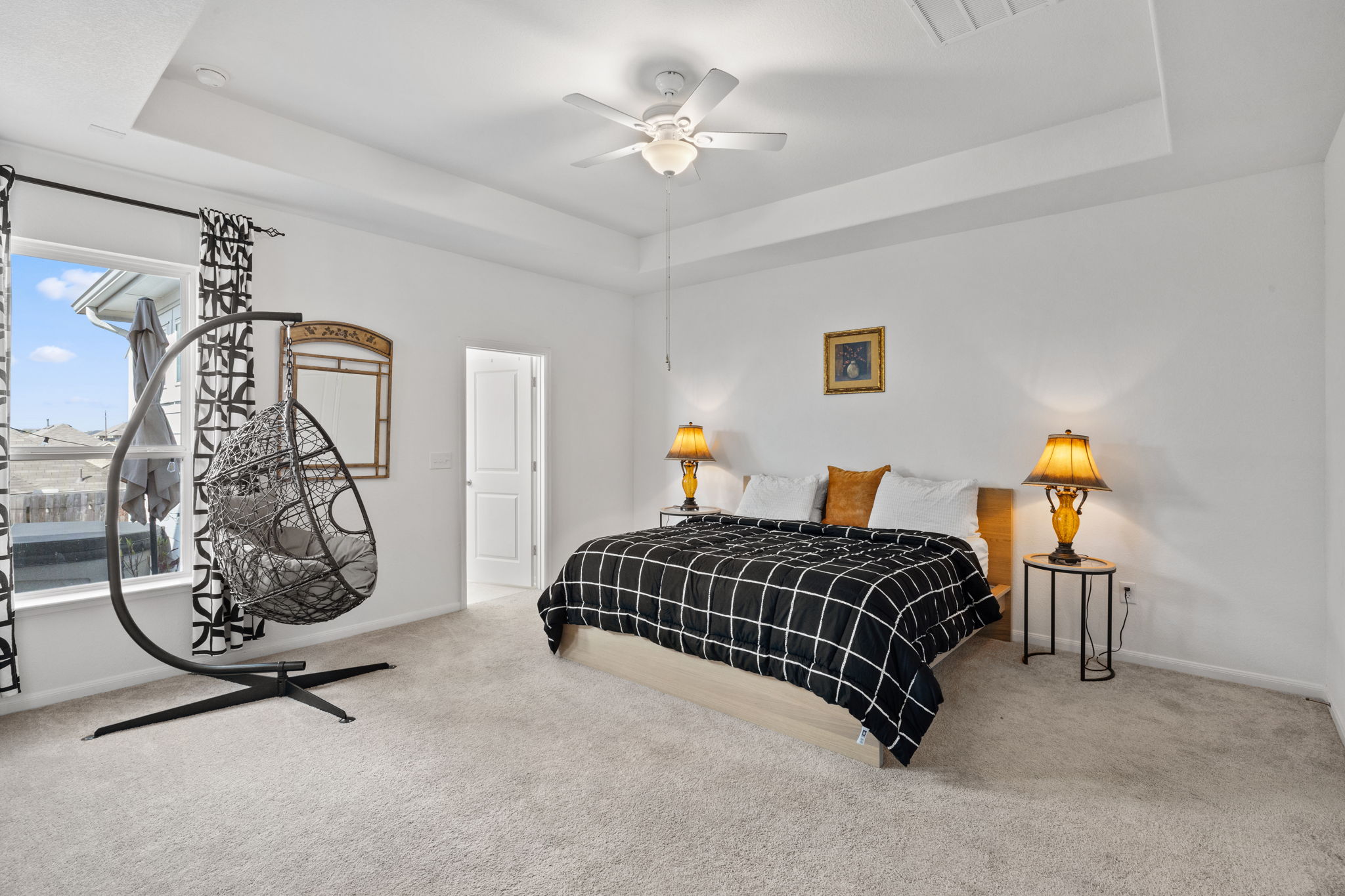 189 Durian Loop Buda, TX 78610 - Photo 14 of 38 Bedroom featuring carpet floors, a raised ceiling, and a ceiling fan