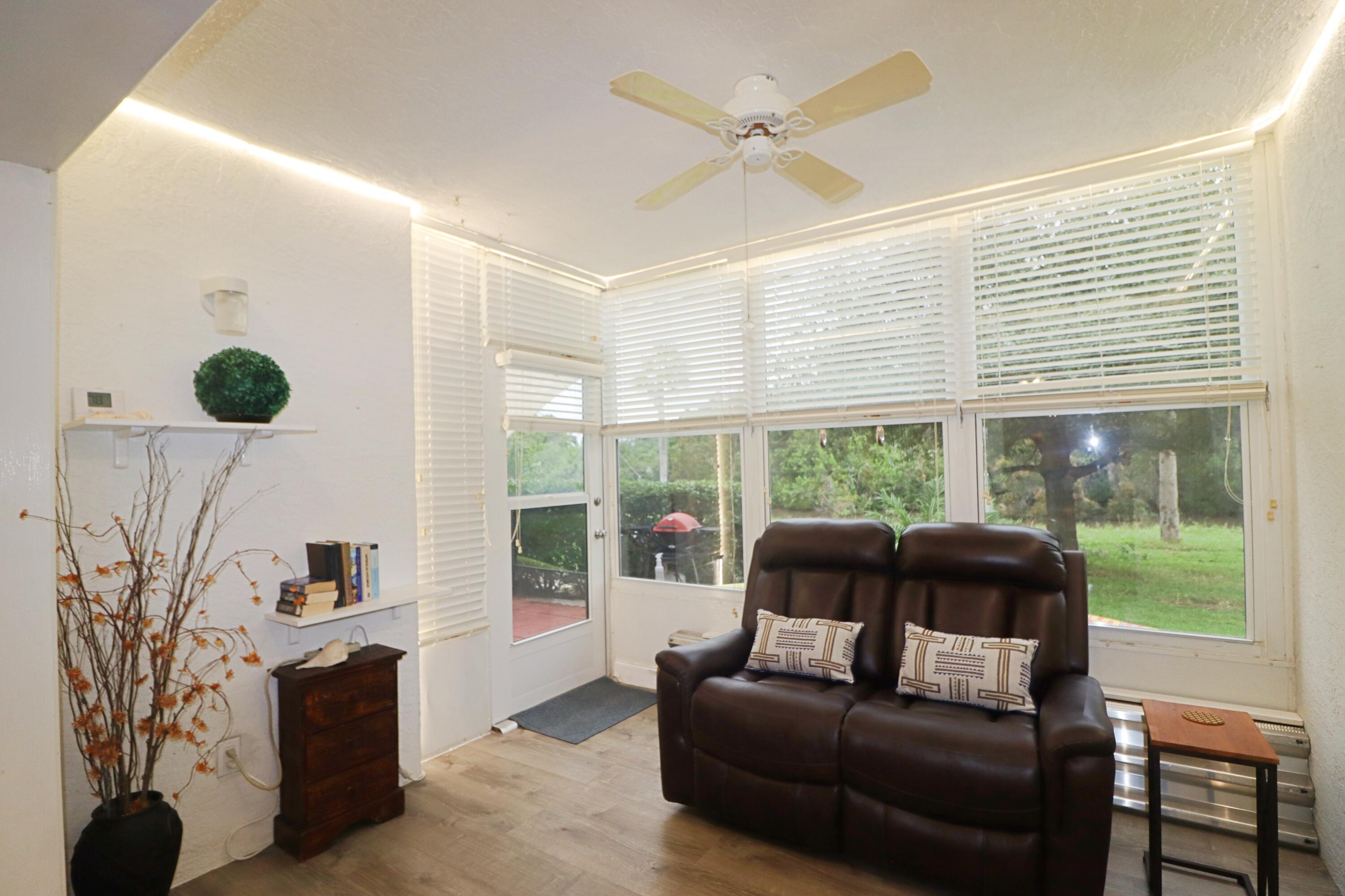133 Lakes End Drive, Unit E1 Fort Pierce, FL 34982 - Photo 11 of 29 a living room with furniture and a large window