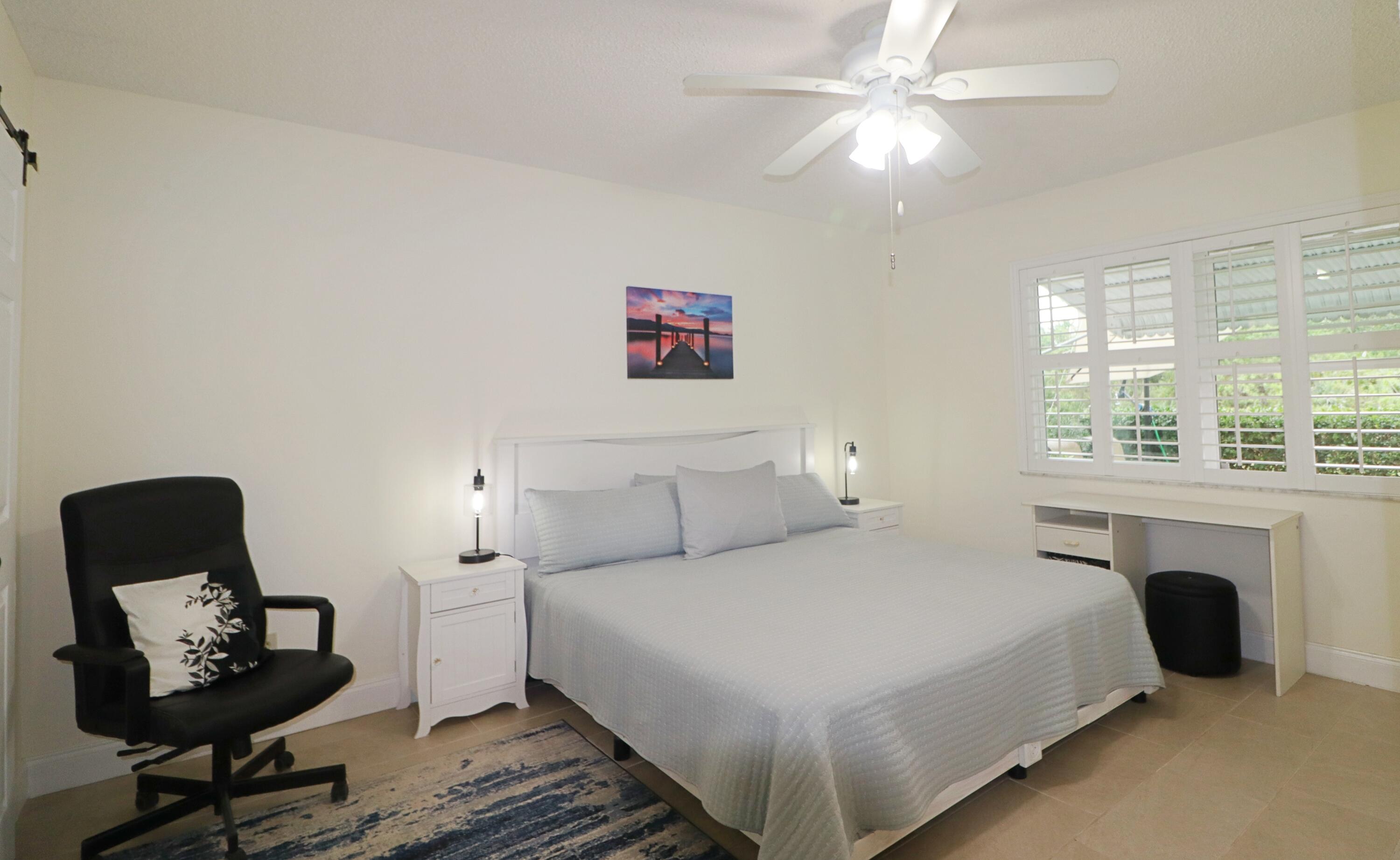 133 Lakes End Drive, Unit E1 Fort Pierce, FL 34982 - Photo 14 of 29 a bedroom with a bed a chair and a fireplace