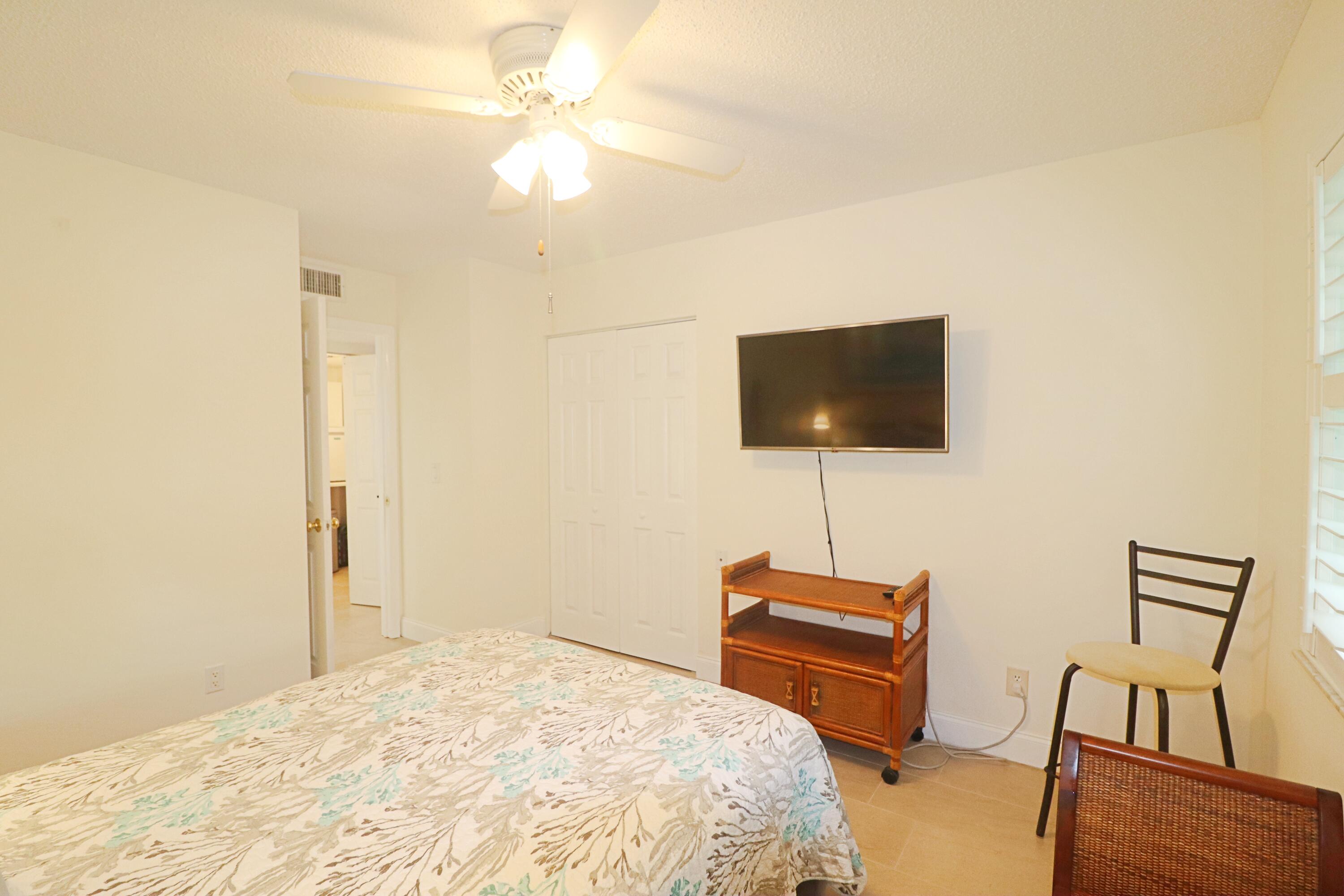 133 Lakes End Drive, Unit E1 Fort Pierce, FL 34982 - Photo 23 of 29 a bedroom with a bed and a flat screen tv