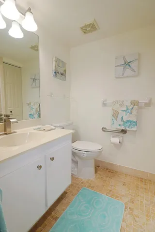 a bathroom with a sink mirror and toilet