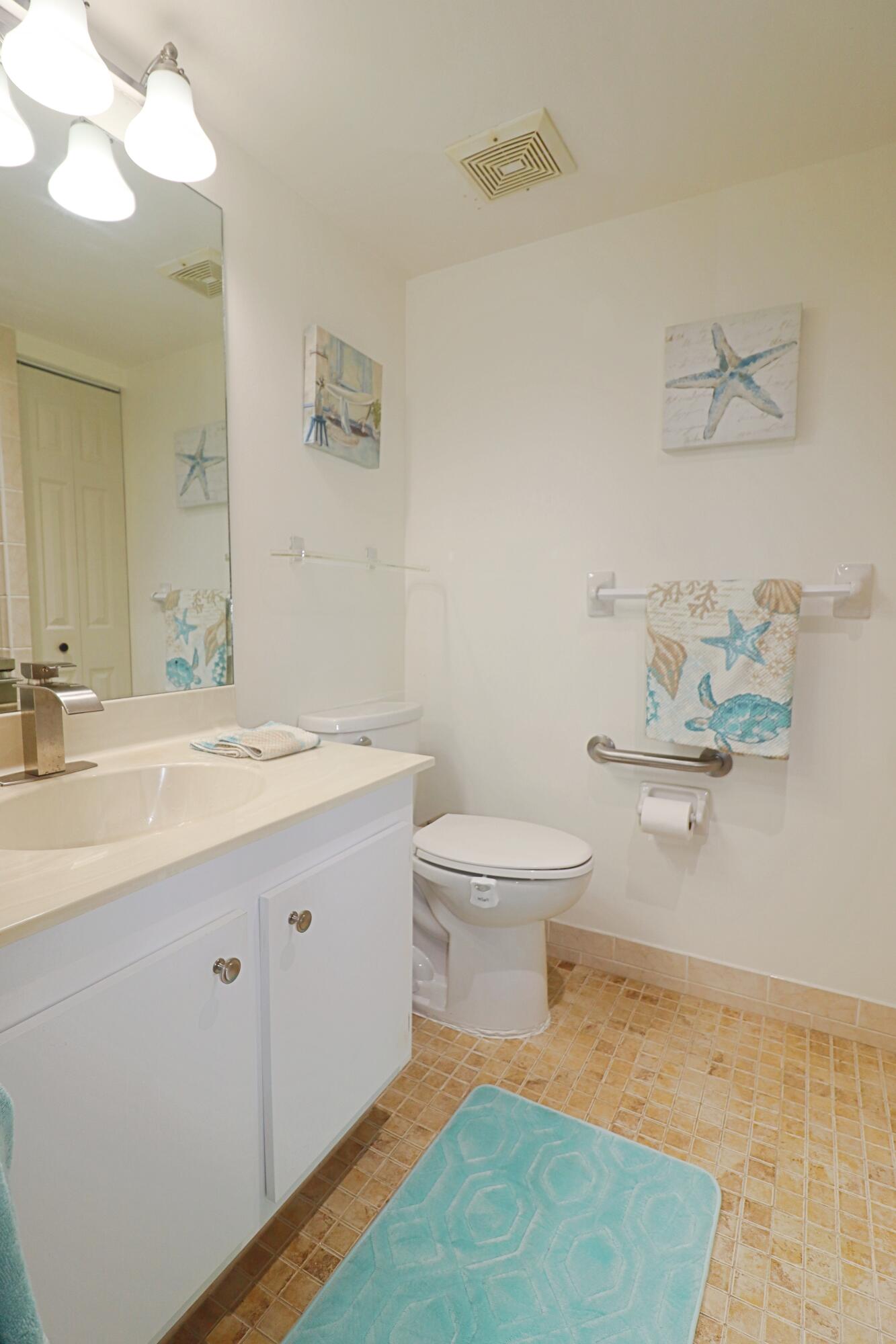 133 Lakes End Drive, Unit E1 Fort Pierce, FL 34982 - Photo 24 of 29 a bathroom with a sink mirror and toilet