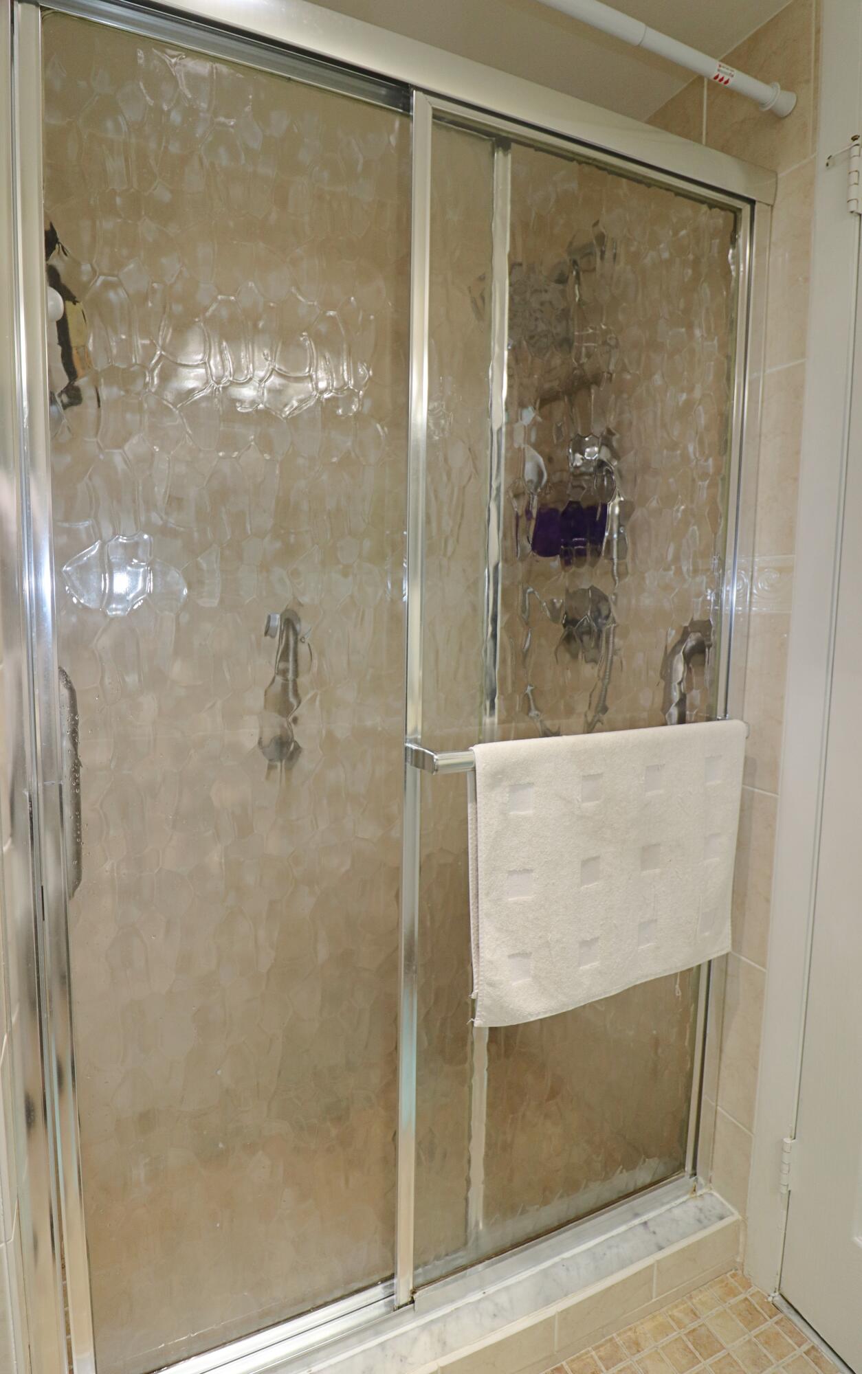 133 Lakes End Drive, Unit E1 Fort Pierce, FL 34982 - Photo 25 of 29 a bathroom with a glass shower door