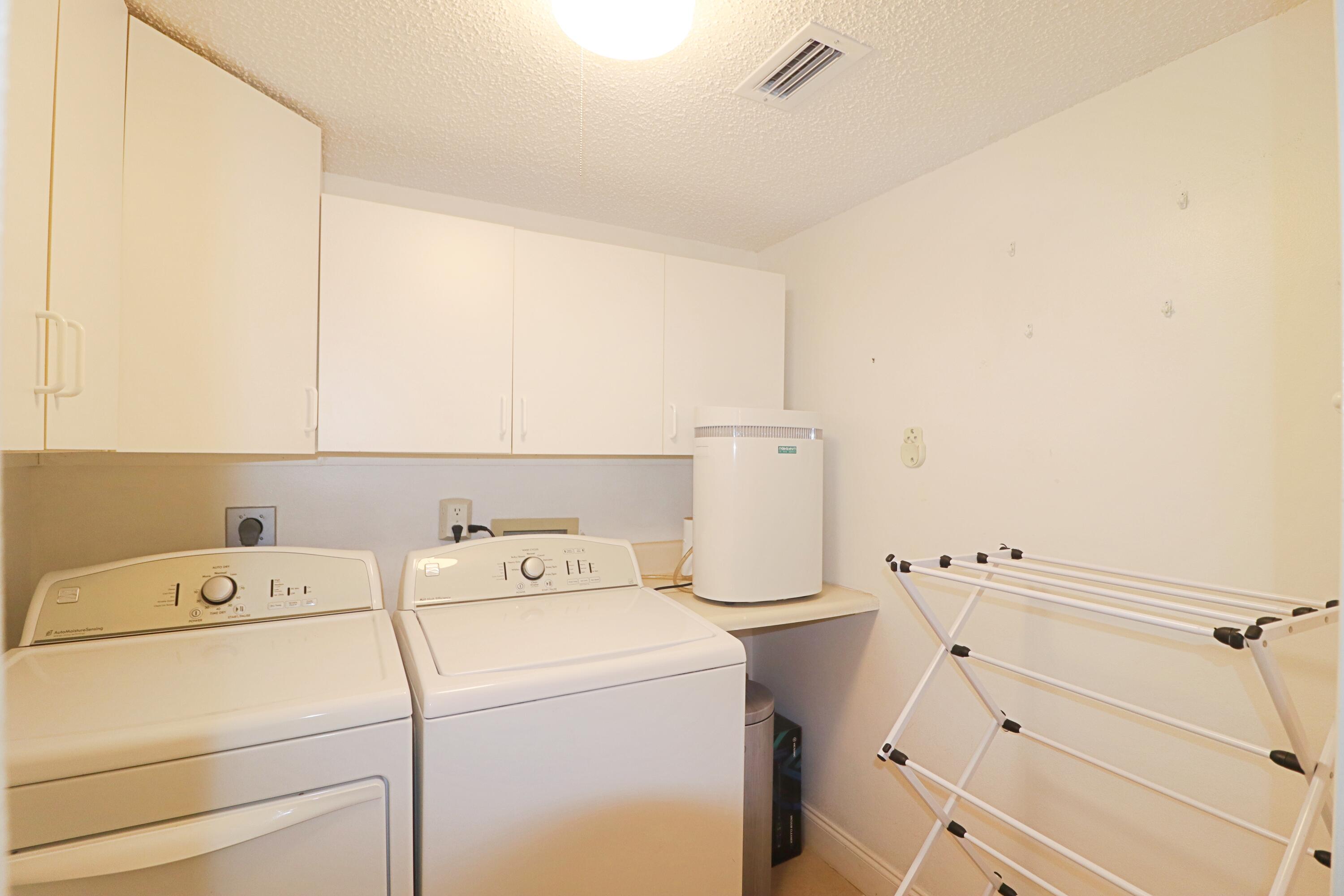 133 Lakes End Drive, Unit E1 Fort Pierce, FL 34982 - Photo 27 of 29 a view of storage and utility room with washer and dryer