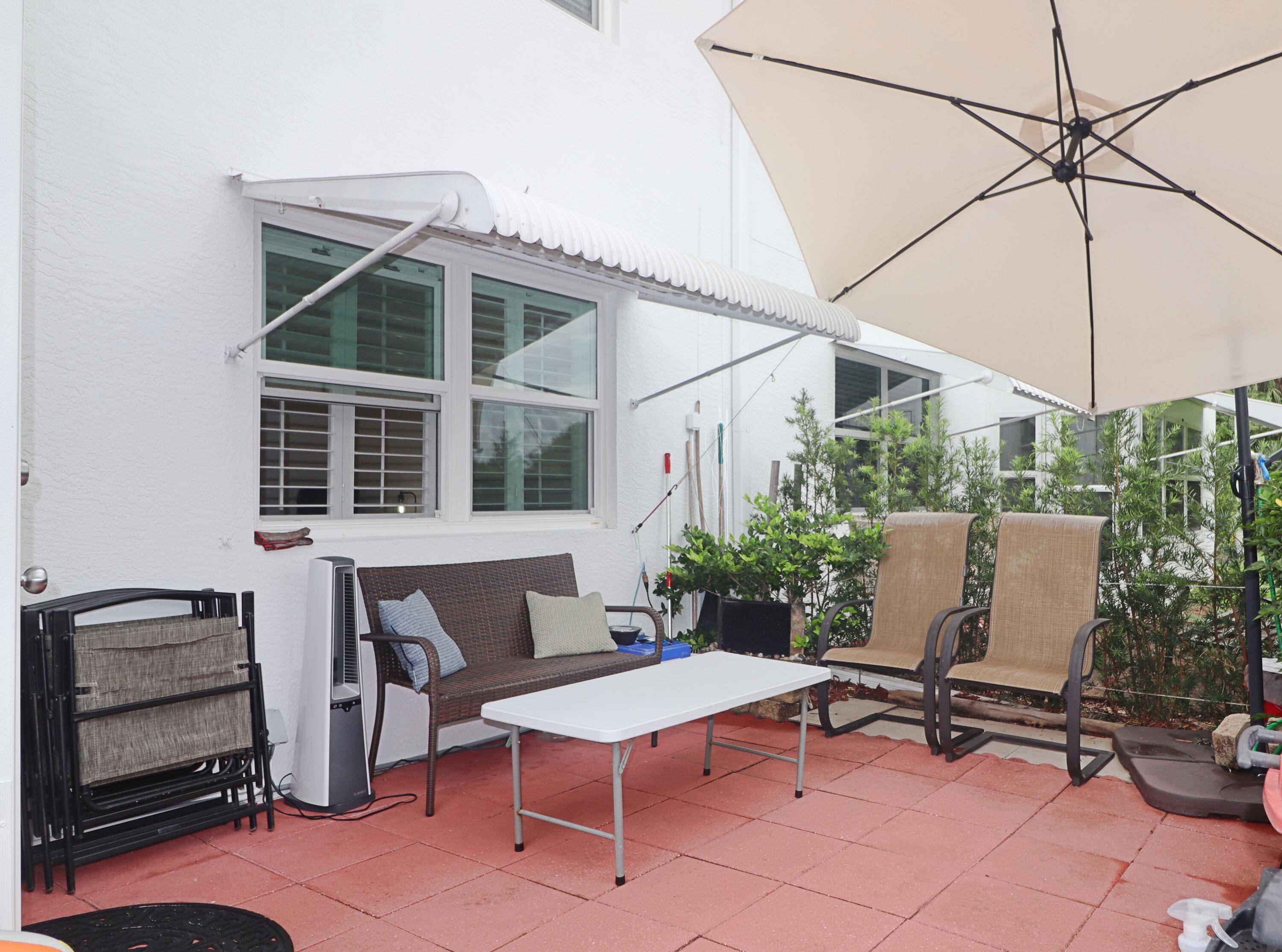 133 Lakes End Drive, Unit E1 Fort Pierce, FL 34982 - Photo 28 of 29 a view of a patio with a table and chairs