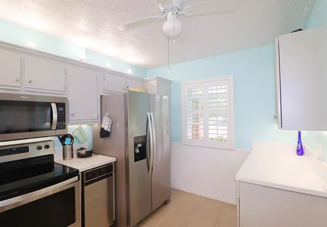 a kitchen with a refrigerator a stove a microwave and cabinets