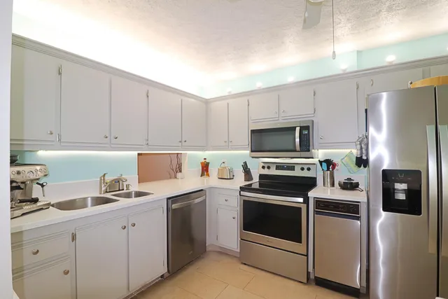 a kitchen with a sink white stove and refrigerator