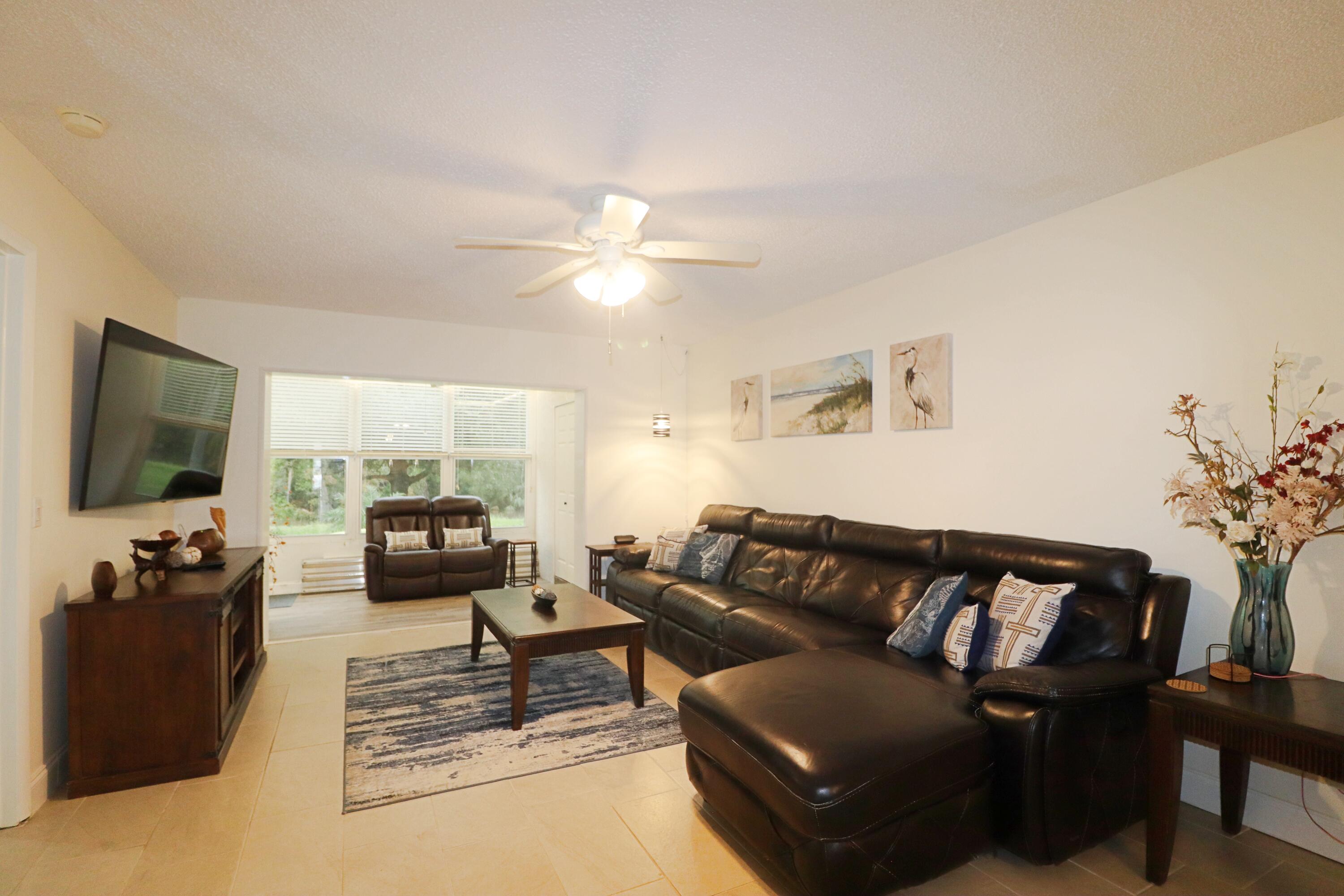 133 Lakes End Drive, Unit E1 Fort Pierce, FL 34982 - Photo 6 of 29 a living room with furniture and a flat screen tv