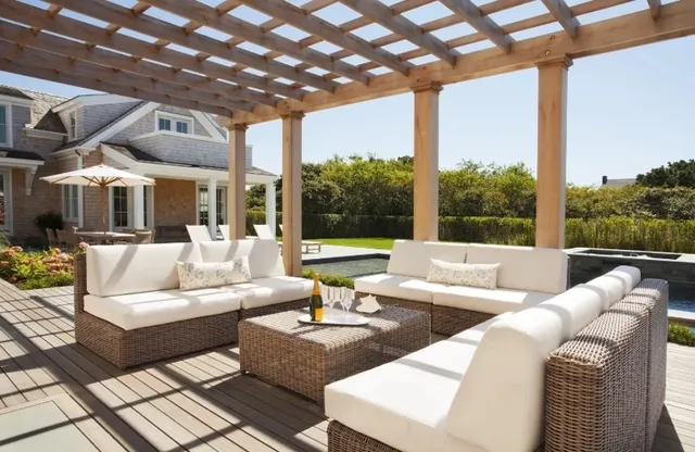 a living room with patio furniture and a potted plant