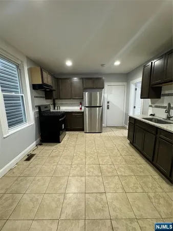 a large kitchen with stainless steel appliances kitchen island granite countertop a sink and cabinets