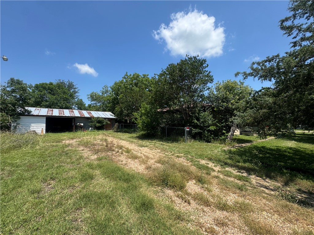 300 South Elm Avenue Cameron, TX 76520 - Photo 2 of 13 View of green lawn featuring a pole building and an outbuilding