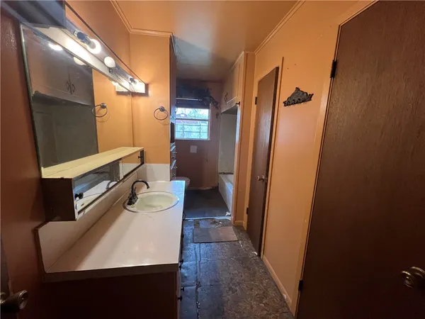 a bathroom with a sink a toilet a mirror and shower